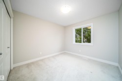 Bright room featuring a double-pane window, neutral-toned walls, and light-colored carpeting - 