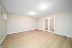 Spacious room featuring light wood-finish flooring, neutral wall tones, and white baseboards - 