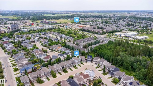 Aerial perspective showcasing a residential area with varied housing styles, surrounded by green spaces and mature trees - 11312 13 Ave Sw, Edmonton, AB 