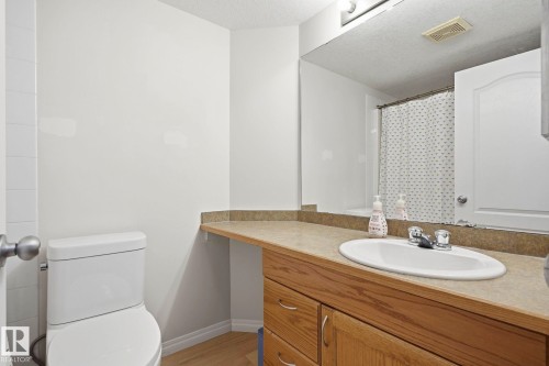 Bathroom featuring a vanity with an integrated sink, laminate countertop, and wood-finish cabinetry - 426 3425 19 Street, Edmonton, AB 