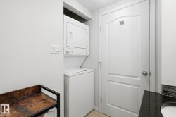 Dedicated laundry area featuring a stacked washer and dryer unit - 