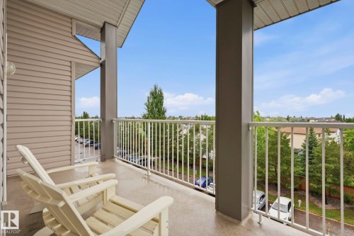 Private balcony with durable flooring, white metal railing, and a slatted exterior wall - 426 3425 19 Street, Edmonton, AB 