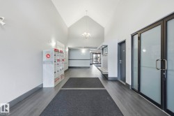 Vaulted ceiling entrance featuring wood-finish flooring, recessed lighting, and mailboxes - 
