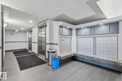 Modern mailroom featuring extensive secured mailboxes, stone-finish bench seating, and wood-finish flooring - 