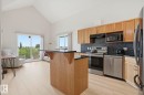 Open-concept kitchen and living area featuring a vaulted ceiling and wood-finish flooring - 426 3425 19 Street, Edmonton, AB 