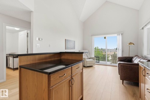 Open-concept living space featuring wood-finish flooring and vaulted ceilings - 426 3425 19 Street, Edmonton, AB 