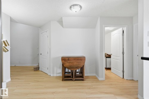 Light wood-finish flooring throughout, complemented by white baseboards and walls - 426 3425 19 Street, Edmonton, AB 