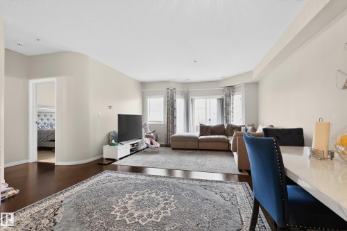 Open-concept living space featuring wood-finish flooring, recessed lighting, and a bay window - 226 4304 139 Avenue, Edmonton, AB 