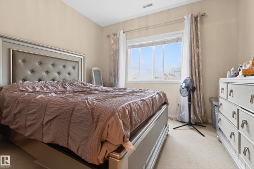 Carpeted room featuring a large window with white framing - 226 4304 139 Avenue, Edmonton, AB 