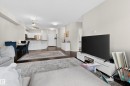 Open-concept living area featuring dark wood-finish flooring, recessed lighting, and light-toned walls - 226 4304 139 Avenue, Edmonton, AB 