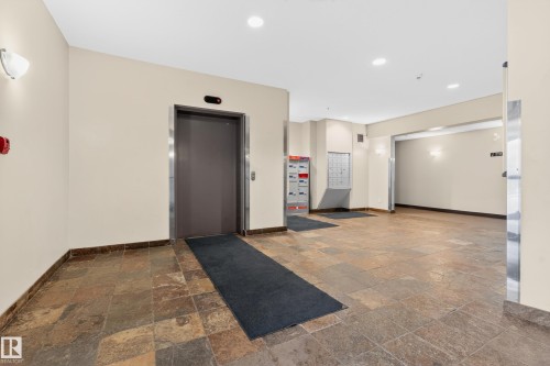 Lobby featuring a slate tile floor and a central elevator with stainless steel trim - 226 4304 139 Avenue, Edmonton, AB 