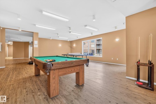 Spacious recreation room featuring wood-finish flooring and ample overhead lighting - 226 4304 139 Avenue, Edmonton, AB 