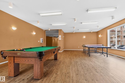 Recreation room featuring a wood-finish flooring, recessed lighting, and wall sconces - 226 4304 139 Avenue, Edmonton, AB 