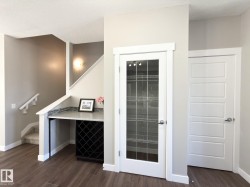 Built-in desk area with a stone-finish countertop, integrated wine rack, and wood-finish flooring - 