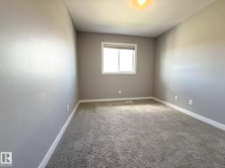 Carpeted room featuring light gray walls and a single window with a roller shade - 