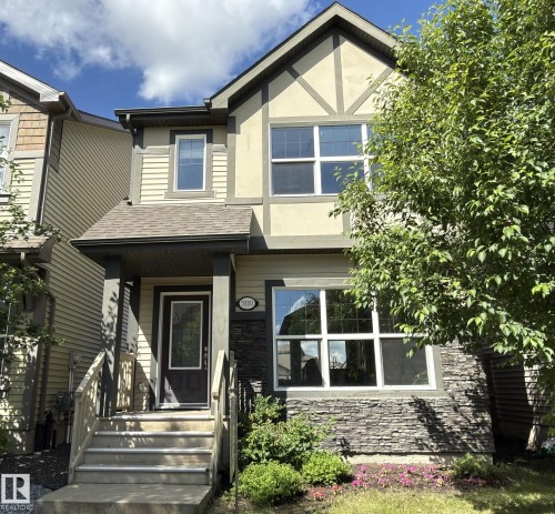 Two-story stucco and siding exterior featuring dark trim accents - 3110 Paisley Road, Edmonton, AB 