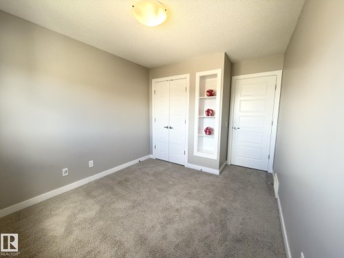 Neutral-toned room featuring plush carpeting and white trim - 3110 Paisley Road, Edmonton, AB 