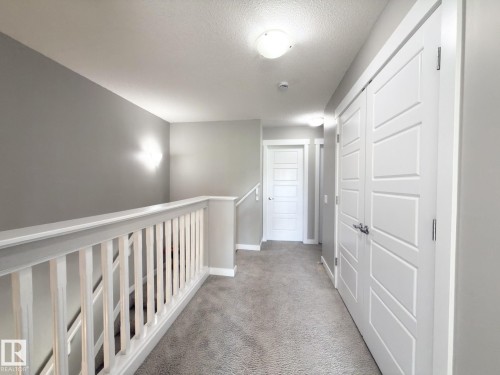 Upper level hallway featuring light gray wall paint, white trim, and light gray carpeted flooring - 3110 Paisley Road, Edmonton, AB 