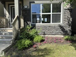 Exterior facade featuring stacked stone accents, horizontal siding, and a prominent front window with grid panes - 