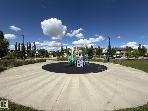 Community playground featuring a colorful play structure on a dark safety surface - 3110 Paisley Road, Edmonton, AB 