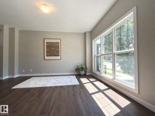 Expansive multipane window with white trim, dark wood-finish flooring, light tan walls, and white baseboards - 3110 Paisley Road, Edmonton, AB 