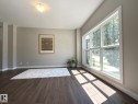 Expansive multipane window with white trim, dark wood-finish flooring, light tan walls, and white baseboards - 3110 Paisley Road, Edmonton, AB 