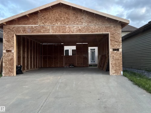 Concrete driveway leading to a framed garage structure - 3110 Paisley Road Sw, Edmonton, AB - Outdoor
