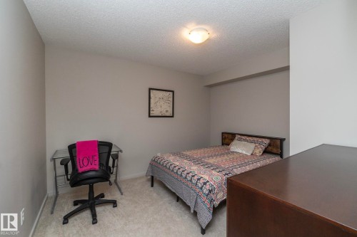 Carpeted room with a textured ceiling, flush-mount lighting, and neutral wall paint - 431 344 Windermere Road, Edmonton, AB - Indoor Photo Showing Bedroom