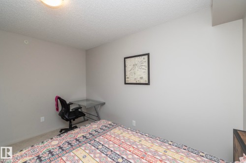 Neutral tone wall color, textured ceiling, and light-colored carpeting - 431 344 Windermere Road, Edmonton, AB - Indoor Photo Showing Bedroom