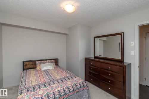 Carpeted room featuring light gray walls, a textured ceiling, and a flush mount ceiling light fixture - 431 344 Windermere Road, Edmonton, AB - Indoor Photo Showing Bedroom