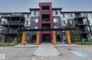 Contemporary multi-story building featuring a red, gray, and light-toned facade - 431 344 Windermere Road, Edmonton, AB  - Outdoor With Balcony With Facade 