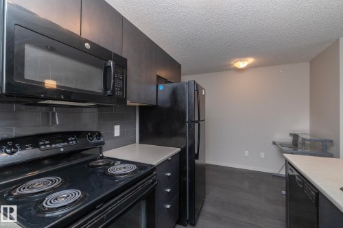 Kitchen featuring a black appliance suite with an over-the-range microwave and electric range - 431 344 Windermere Road, Edmonton, AB - Indoor Photo Showing Kitchen