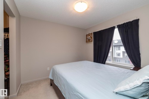 Room featuring neutral wall paint, textured ceiling, and carpet flooring - 431 344 Windermere Road, Edmonton, AB - Indoor Photo Showing Bedroom