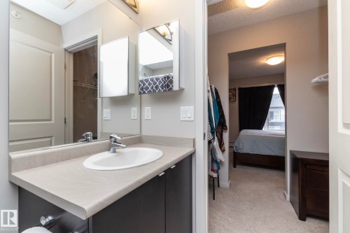 Vanity with an integrated white sink and chrome faucet, set against a full-width mirror - 431 344 Windermere Road, Edmonton, AB - Indoor Photo Showing Bathroom