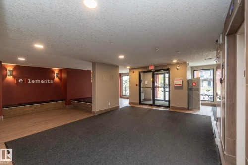 Lobby area featuring wood-finish flooring, recessed lighting, and wall sconces - 431 344 Windermere Road, Edmonton, AB - Indoor Photo Showing Other Room