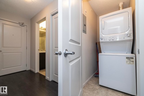 Dedicated laundry area featuring a white stackable washer and dryer unit - 431 344 Windermere Road, Edmonton, AB - Indoor Photo Showing Laundry Room