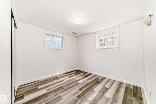 Room with wood-finish flooring, white baseboards, and two windows - 11937 39 Street Nw, Edmonton, AB 