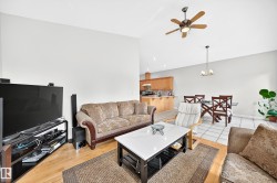 Open-concept living area with a vaulted ceiling and a ceiling fan - 