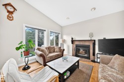 Living area featuring a vaulted ceiling and hardwood flooring - 