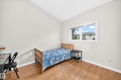 Light-filled room featuring wood-finish flooring, a white trim window, and neutral wall paint - 