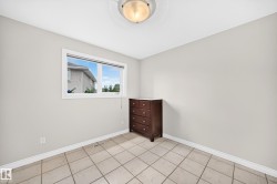Room featuring light gray walls, white trim, and neutral-toned tile flooring - 