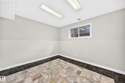 Recessed rectangular window with white trim, marble-patterned floor tiles, dark marble-patterned border, neutral wall paint, and white baseboards - 