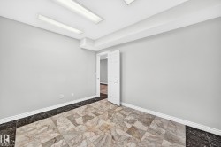Room featuring large format marble-look floor tiles with a contrasting dark tile border - 