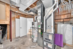 Utility space featuring a water heater, furnace, exposed ductwork, and PEX plumbing - 