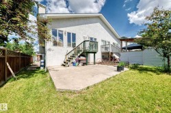 Stucco exterior featuring multiple windows and two elevated decks with wood railings and stairs - 