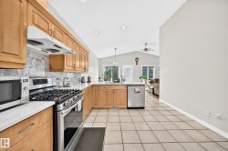 Kitchen featuring wood cabinetry, white countertops, tile flooring, and stainless steel appliances including a gas range and dishwasher - 