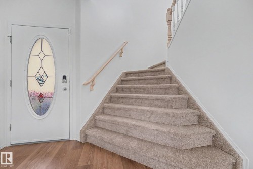 Entryway featuring a white door with an oval stained-glass insert and smart lock - 262 Dunvegan Road, Edmonton, AB 