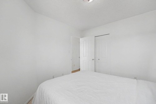 White-painted room featuring a light wood-finish floor and a bifold closet door - 262 Dunvegan Road, Edmonton, AB 