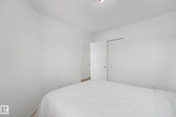 White-painted room featuring a light wood-finish floor and a bifold closet door - 