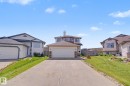 Two-story residence featuring a concrete driveway and an attached two-car garage with a white overhead door - 262 Dunvegan Road, Edmonton, AB 